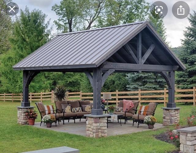 photo of outdoor living shelter with dining and tv living spaces.